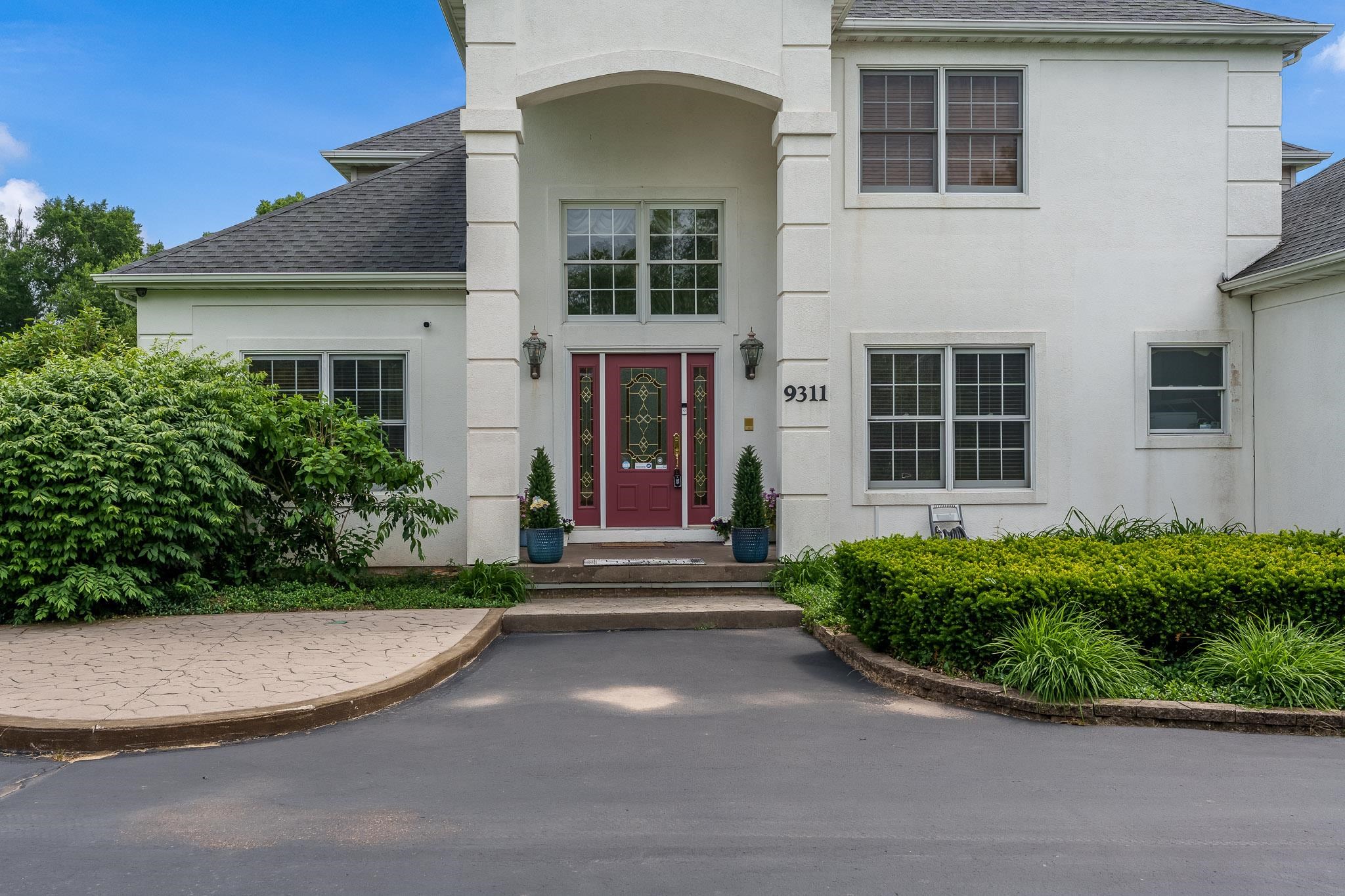 9311 Ridgeview Road Belvidere, IL 61008 - Photo 15 of 89 a view of a brick house with potted plants and large windows