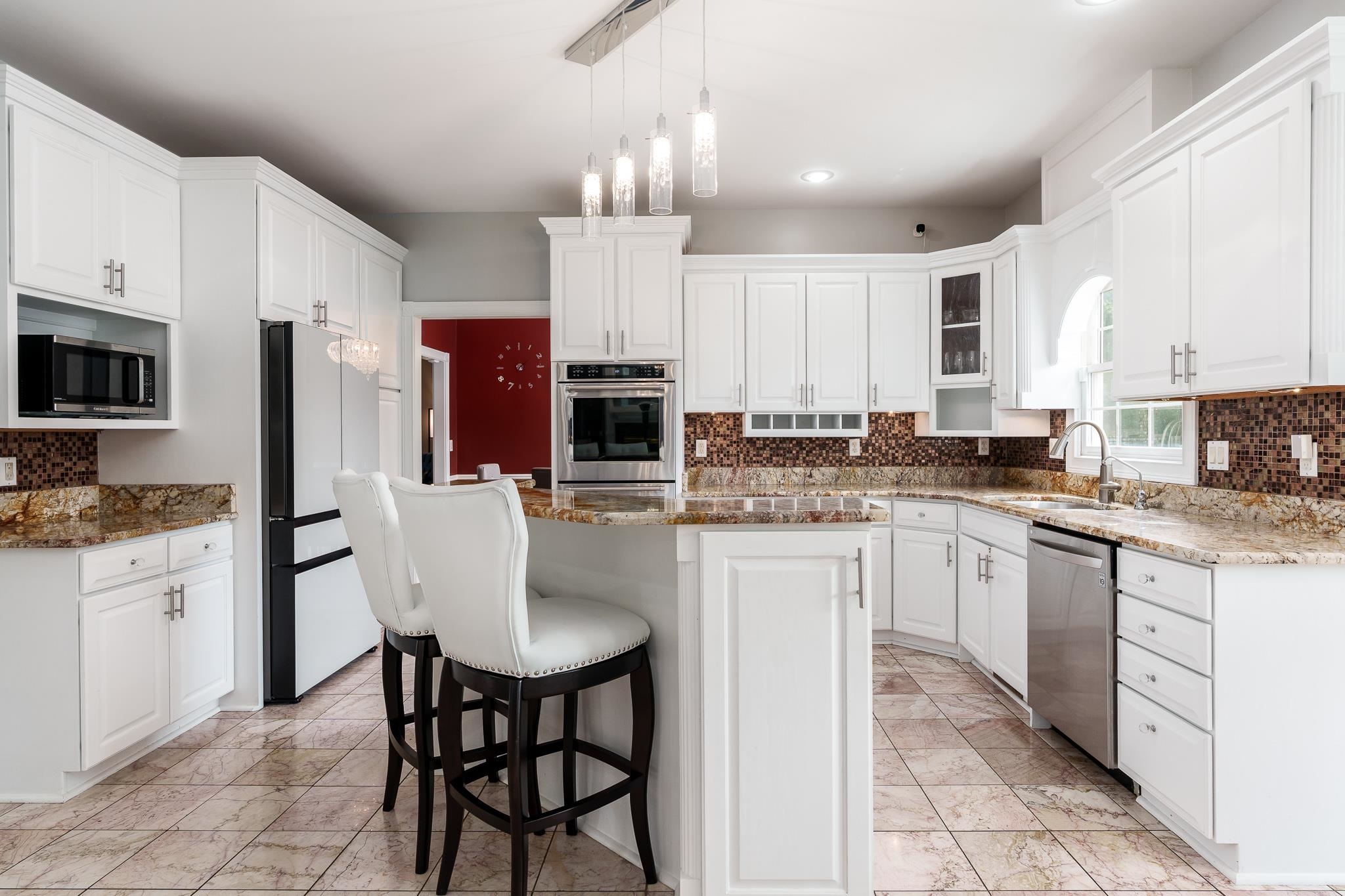 9311 Ridgeview Road Belvidere, IL 61008 - Photo 24 of 89 a kitchen with stainless steel appliances granite countertop a stove a sink a microwave a refrigerator and white cabinets with wooden floor