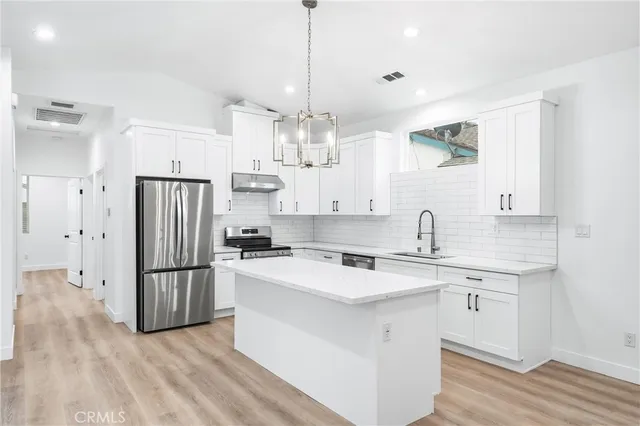 a kitchen with stainless steel appliances a sink and a refrigerator