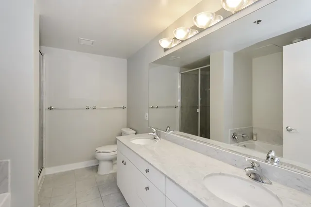 a bathroom with a granite countertop sink a toilet and a mirror