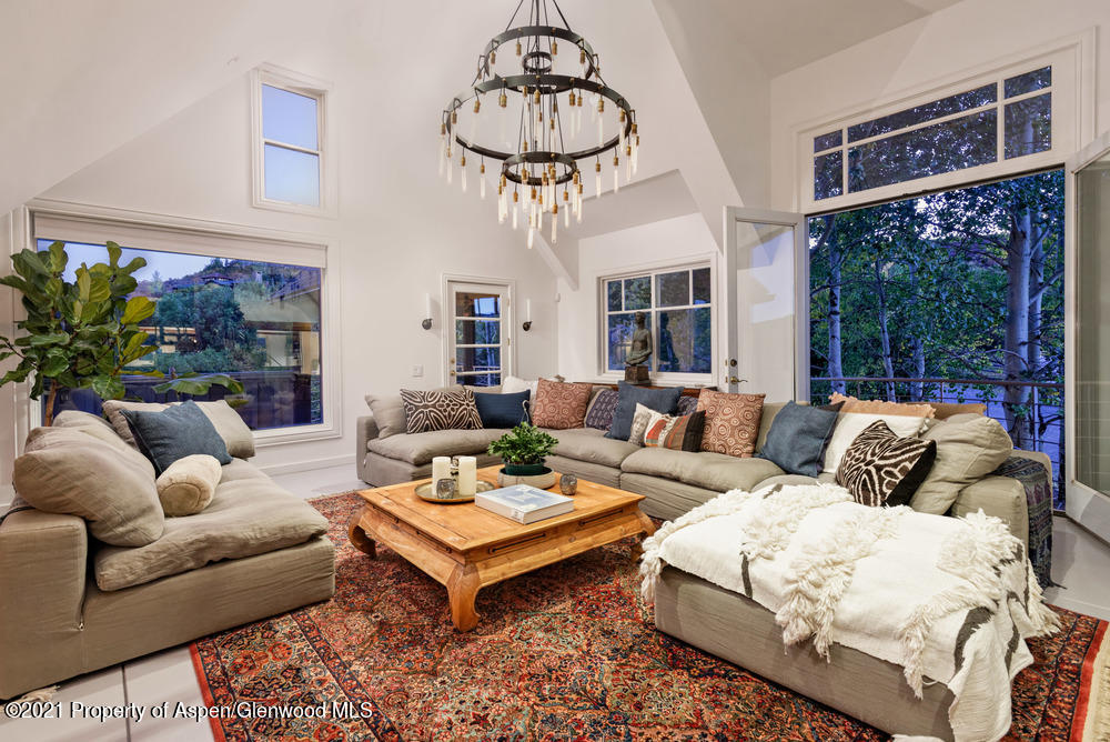 a living room with furniture a chandelier and a table