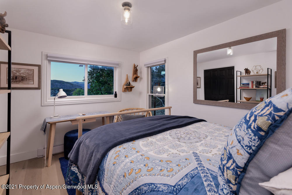 2661 Juniper Hill Road Aspen, CO 81611 - Photo 13 of 31 a bedroom with a bed and a large mirror on the dresser