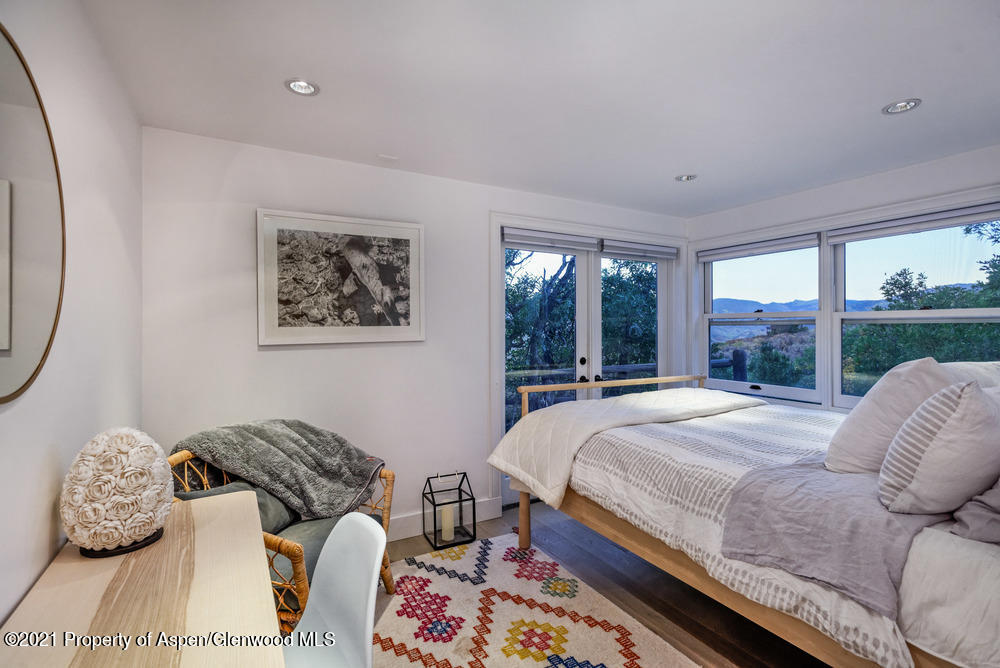 2661 Juniper Hill Road Aspen, CO 81611 - Photo 16 of 31 a bedroom with a bed a mirror and a large window
