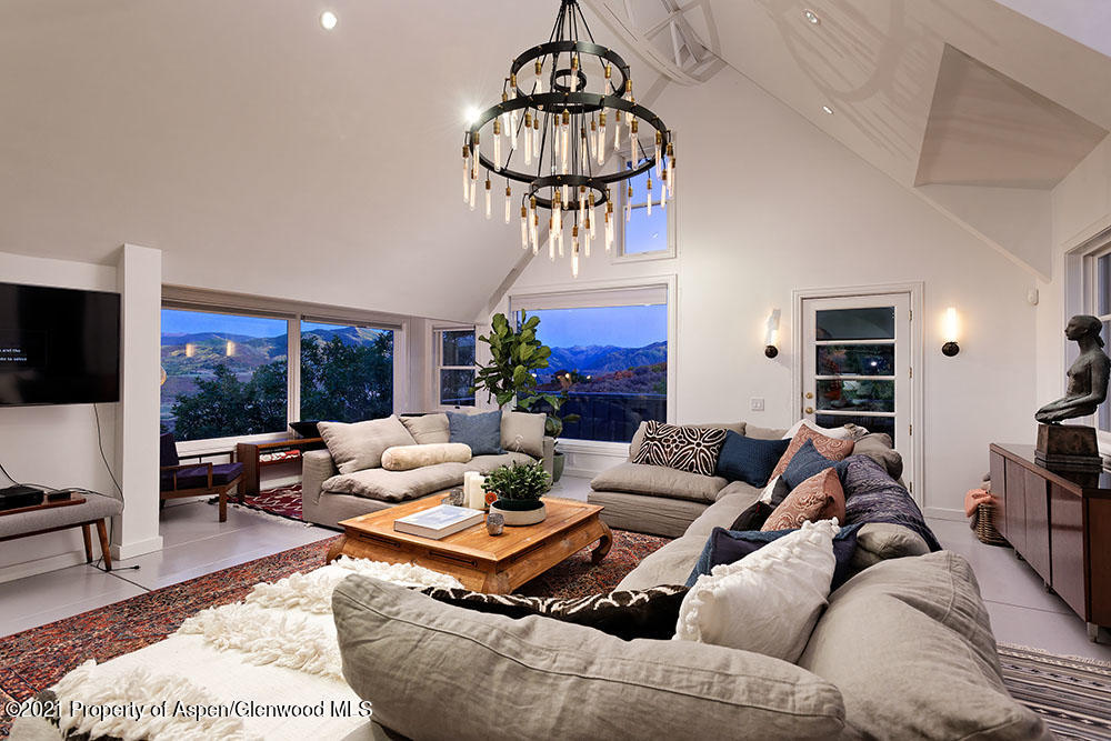 2661 Juniper Hill Road Aspen, CO 81611 - Photo 3 of 31 a living room with furniture a chandelier and a floor to ceiling window