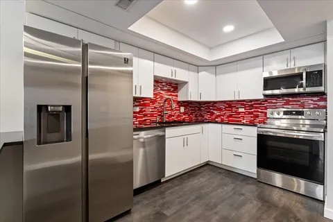 a kitchen with stainless steel appliances granite countertop a refrigerator and a stove