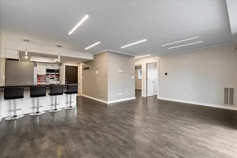 a view of a kitchen with a refrigerator a table and chairs