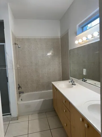 a bathroom with a granite countertop sink a toilet and bathtub