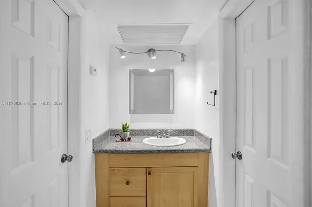 a bathroom with a granite countertop sink a mirror and a