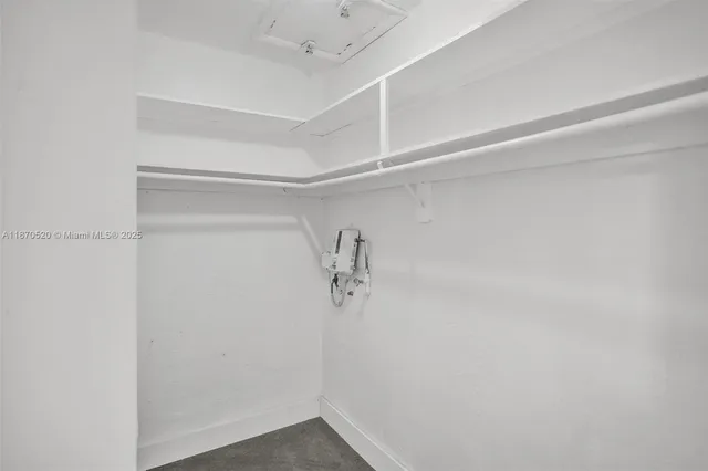 a view of walk in closet with empty racks