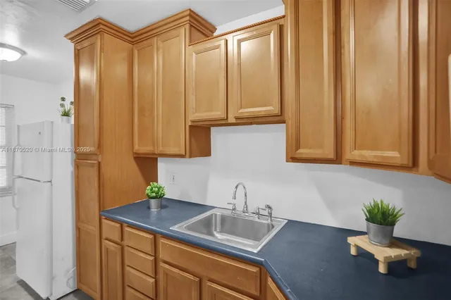 a bathroom with a sink a potted plant and a window