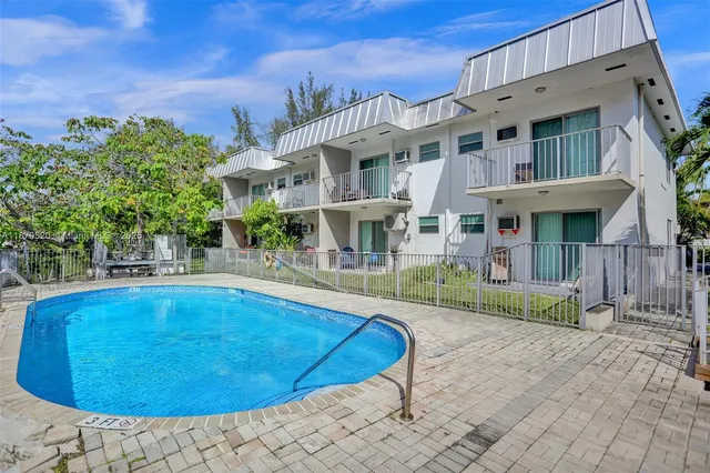 a view of a house with swimming pool and sitting area