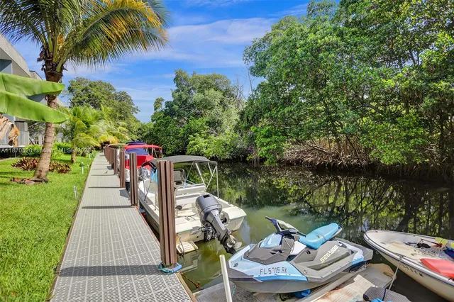 a view of a patio with table and chairs potted plants and a palm tree