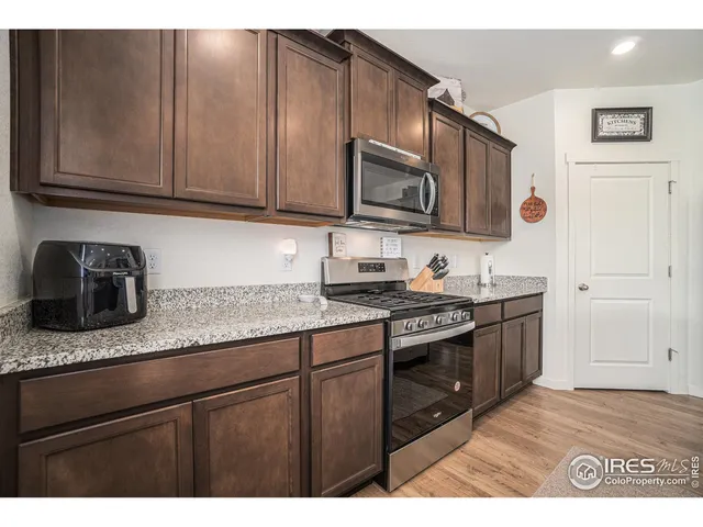 a kitchen with stainless steel appliances granite countertop a sink stove and microwave