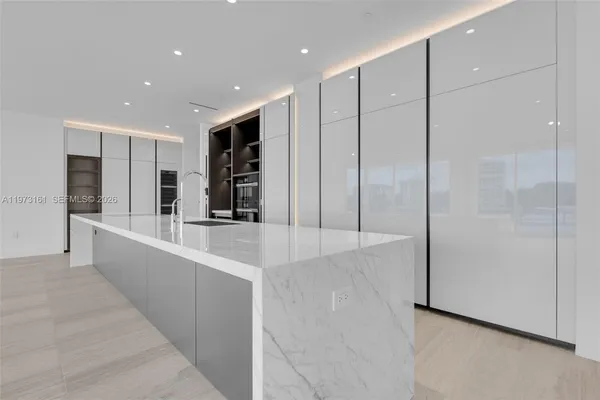 a large kitchen with stainless steel appliances a sink and a refrigerator