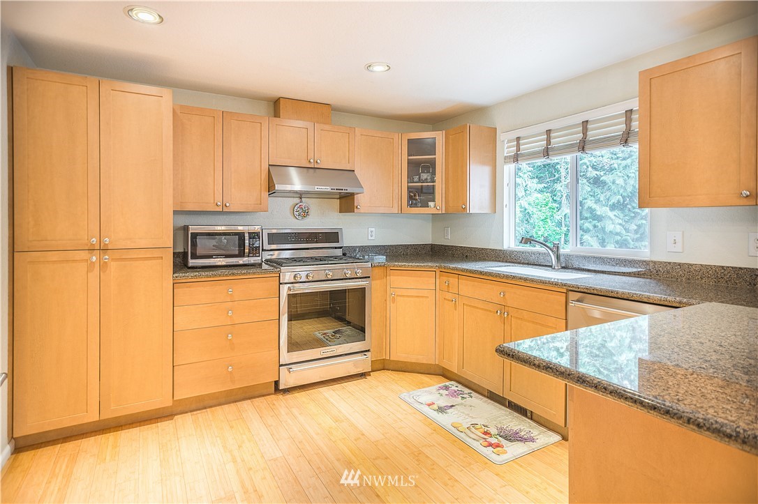 318 161st Place Southeast Bothell, WA 98012 - Photo 8 of 24 a kitchen with a stove a sink and a refrigerator