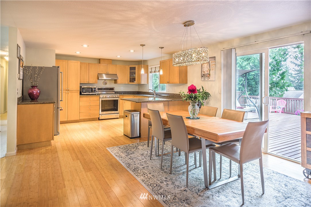 318 161st Place Southeast Bothell, WA 98012 - Photo 9 of 24 a kitchen with stainless steel appliances granite countertop a kitchen island a stove a dining table and chairs