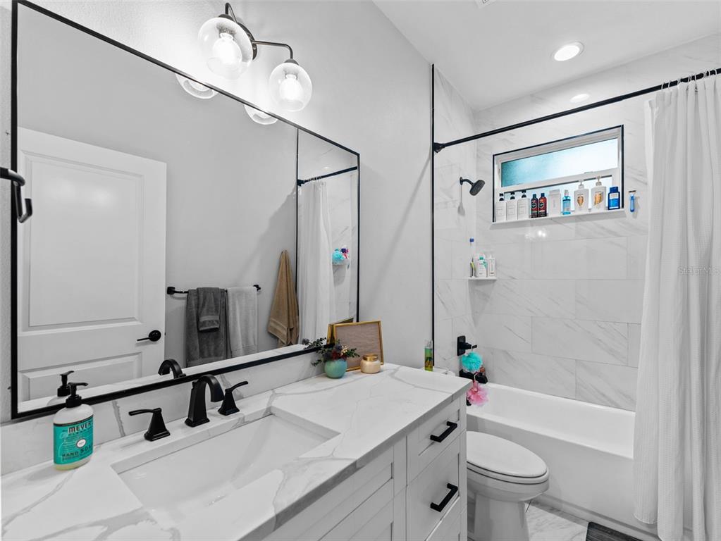 3103 West Leroy Street Tampa, FL 33607 - Photo 19 of 29 a bathroom with a tub a sink and a mirror