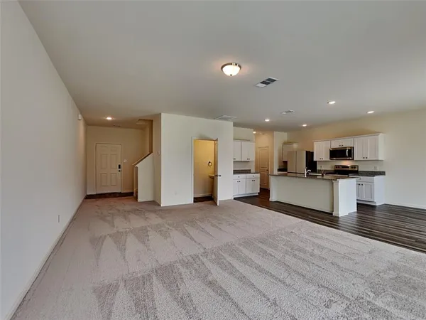 a view of kitchen with kitchen island and stainless steel appliances