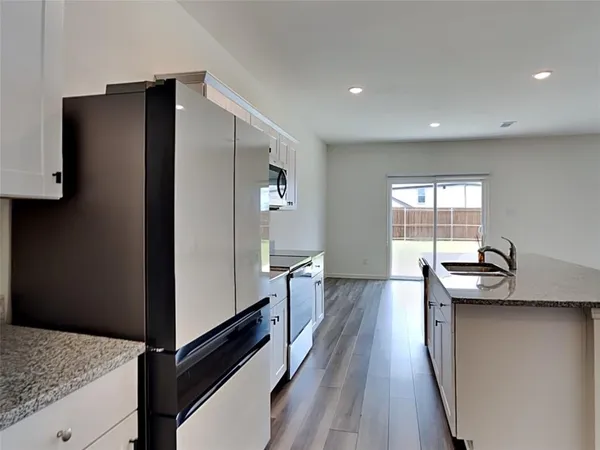a kitchen with stainless steel appliances granite countertop a refrigerator and a sink
