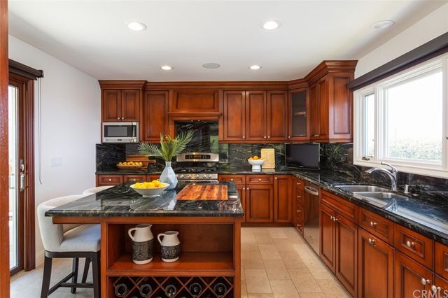 a kitchen with stainless steel appliances granite countertop a sink stove and cabinets