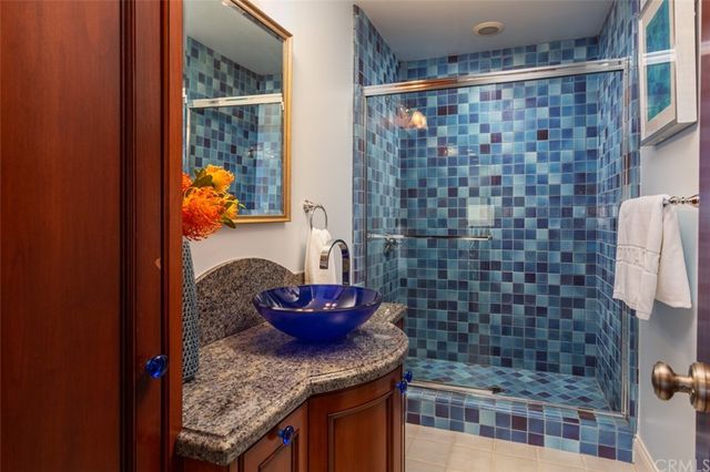 a bathroom with a granite countertop sink a vanity and shower