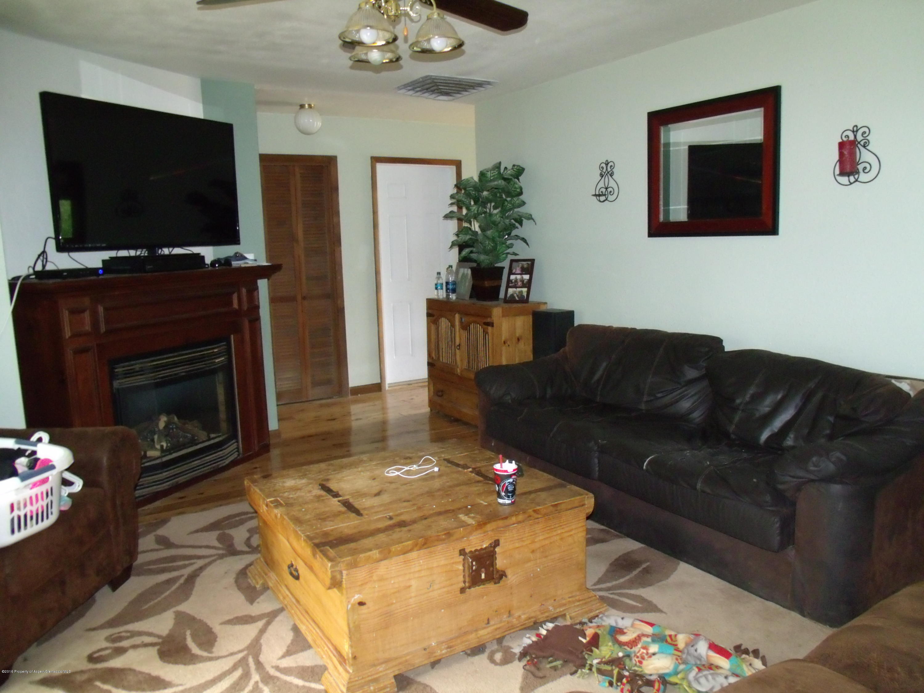 610 Ash Avenue Rifle, CO 81650 - Photo 13 of 18 a living room with furniture a flat screen tv and a fireplace