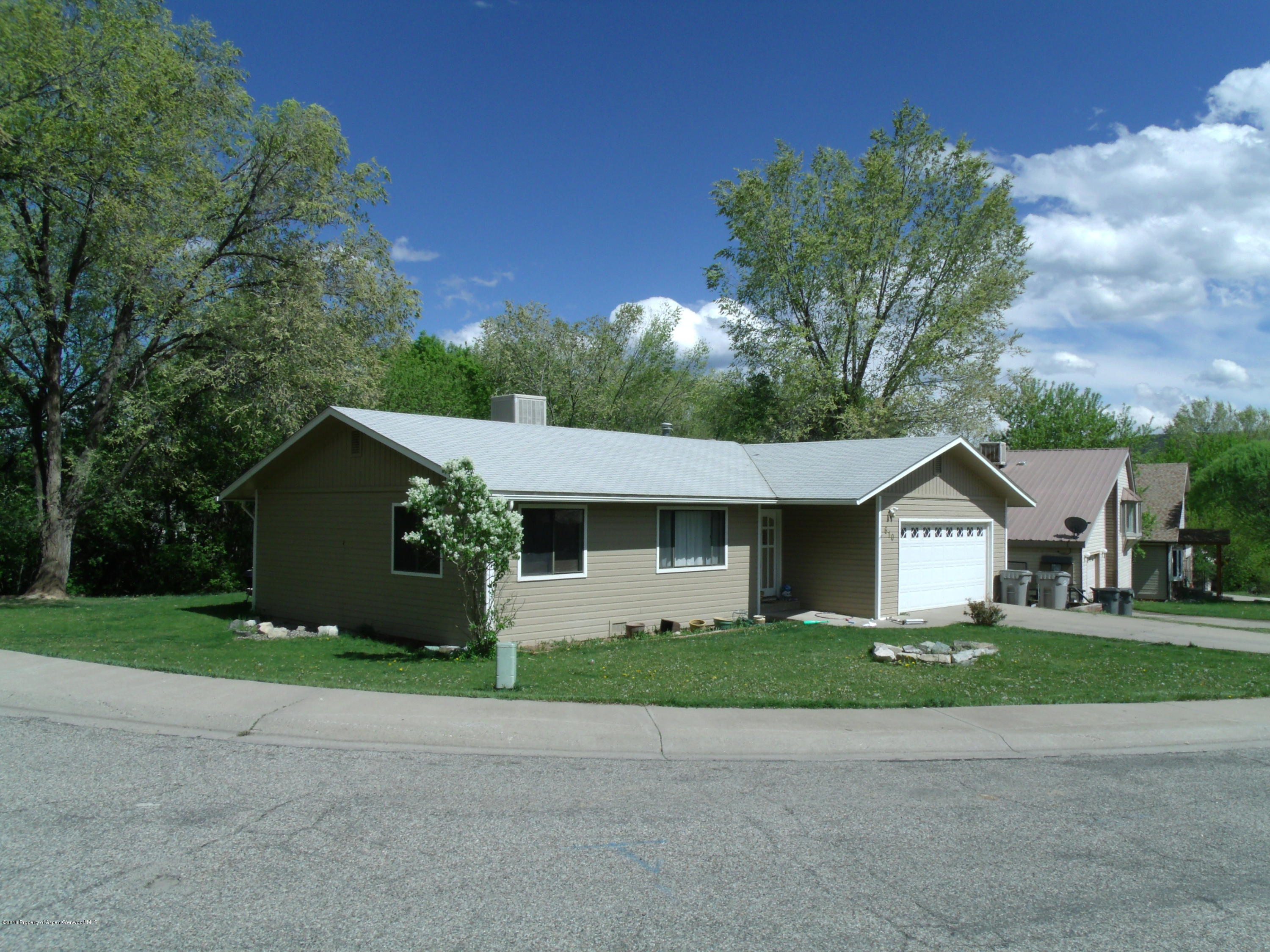 610 Ash Avenue Rifle, CO 81650 - Photo 3 of 18 a front view of a house with a garden and trees