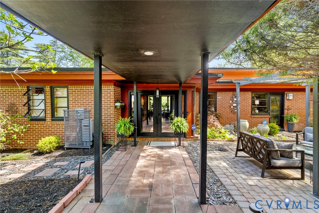 4904 Riverside Drive Richmond, VA 23225 - Photo 1 of 42 a view of a patio with table and chairs potted plants and floor to ceiling window