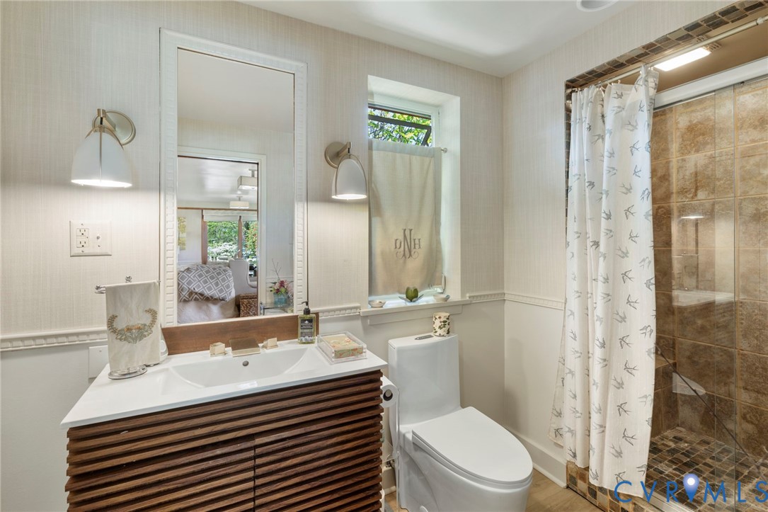 4904 Riverside Drive Richmond, VA 23225 - Photo 21 of 42 a bathroom with a sink a toilet a mirror and shower