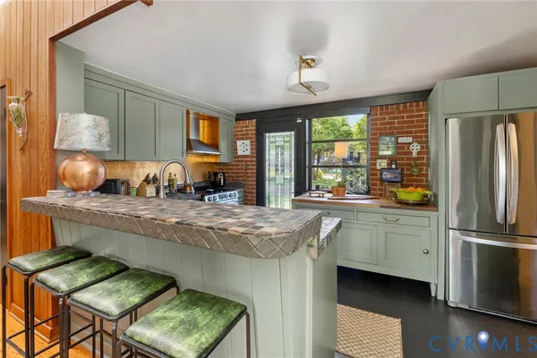 a kitchen with stainless steel appliances granite countertop a stove refrigerator and a sink
