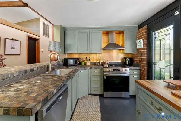 a kitchen with stainless steel appliances granite countertop a stove a sink and a refrigerator