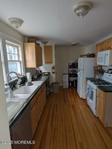 a kitchen with stainless steel appliances granite countertop a sink stove and wooden floor