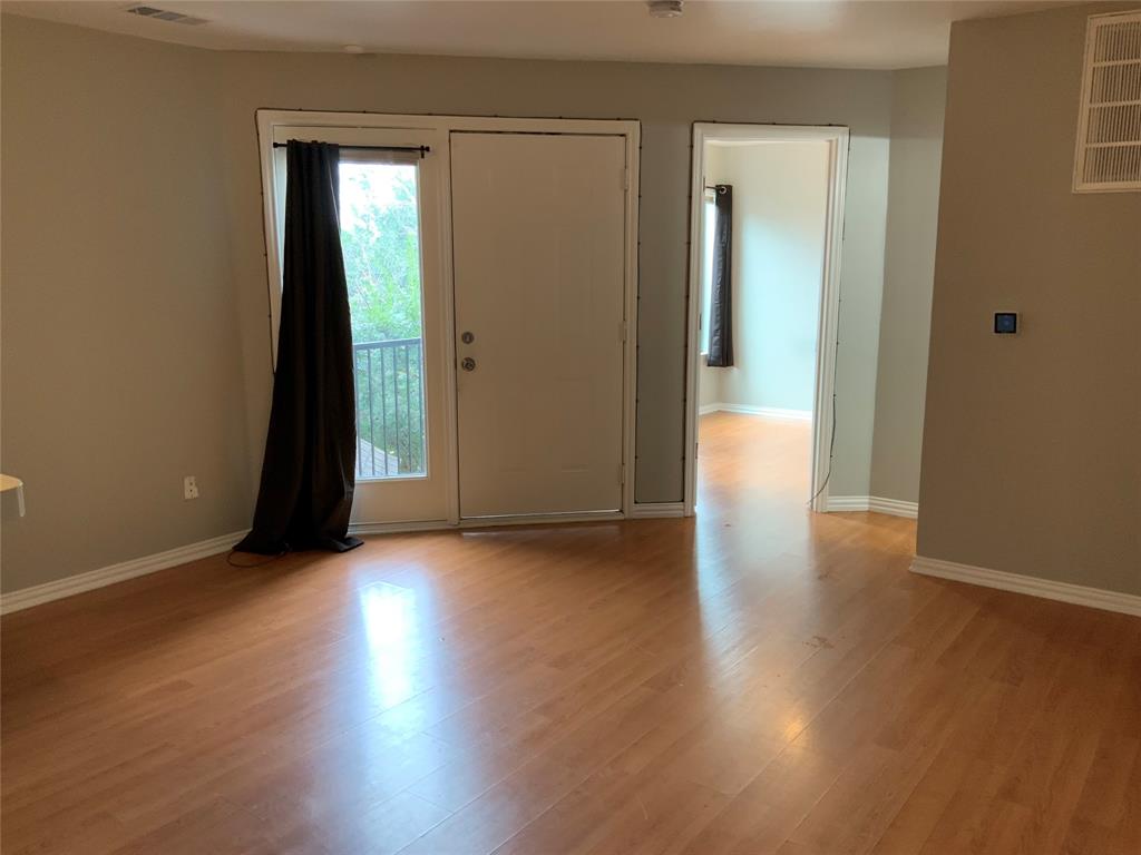 9817 Walnut Street, Unit 305 Dallas, TX 75243 - Photo 5 of 10 an empty room with wooden floor and windows
