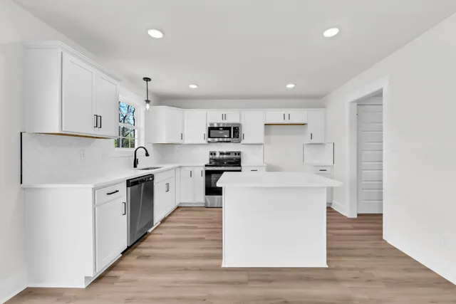 a kitchen with stainless steel appliances sink refrigerator and cabinets