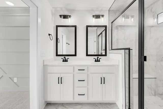 a bathroom with double vanity sinks and a mirror