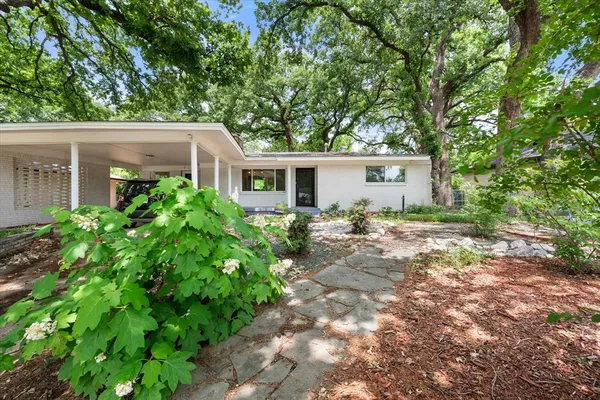 a front view of house with yard and trees around