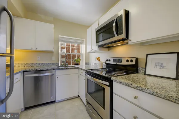 a kitchen with stainless steel appliances granite countertop a stove and a microwave