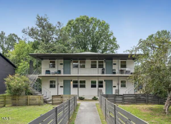 a front view of a house with a garden and lake view