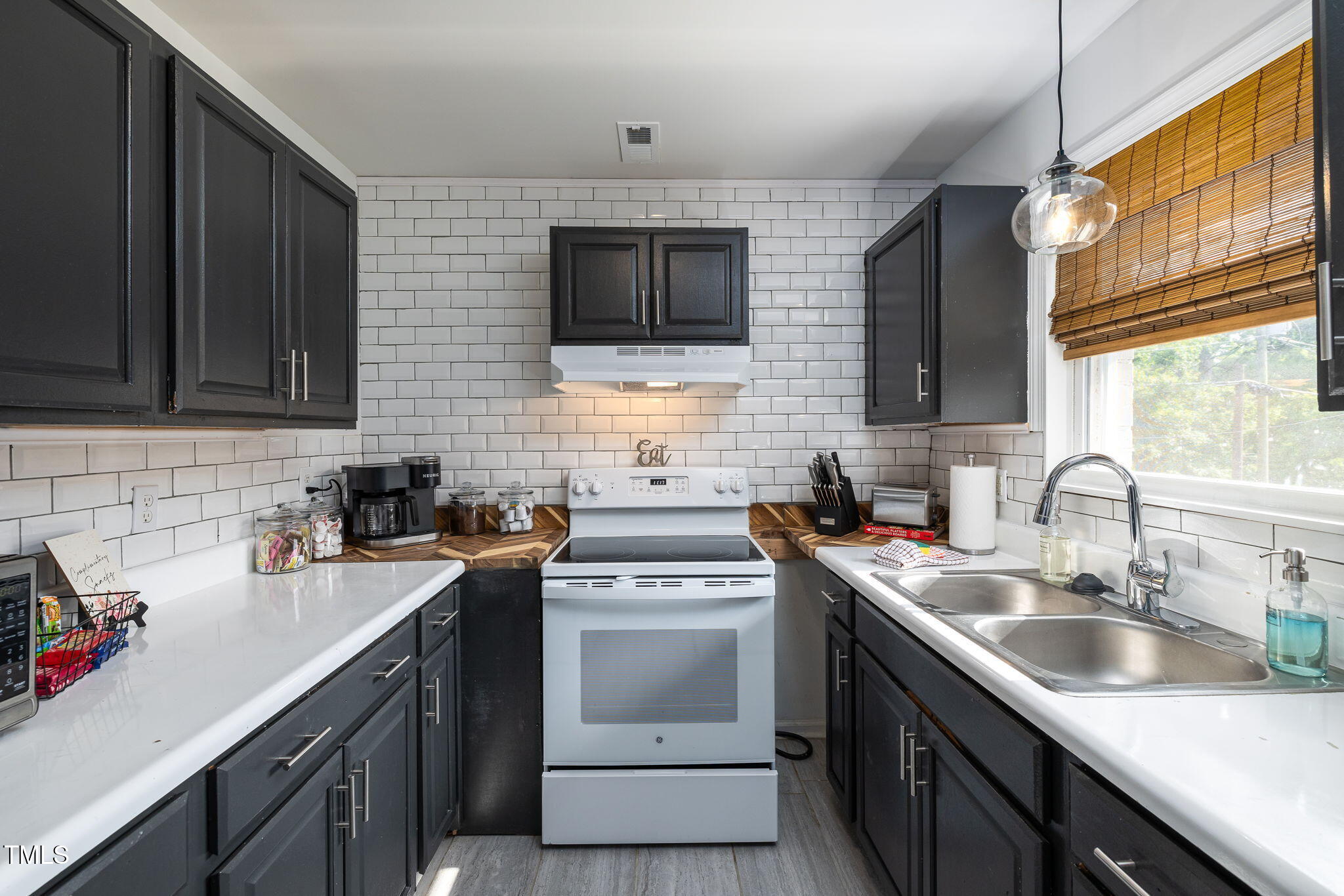 1911 Morehead Avenue Durham, NC 27707 - Photo 21 of 25 a kitchen with stainless steel appliances granite countertop a sink stove and microwave