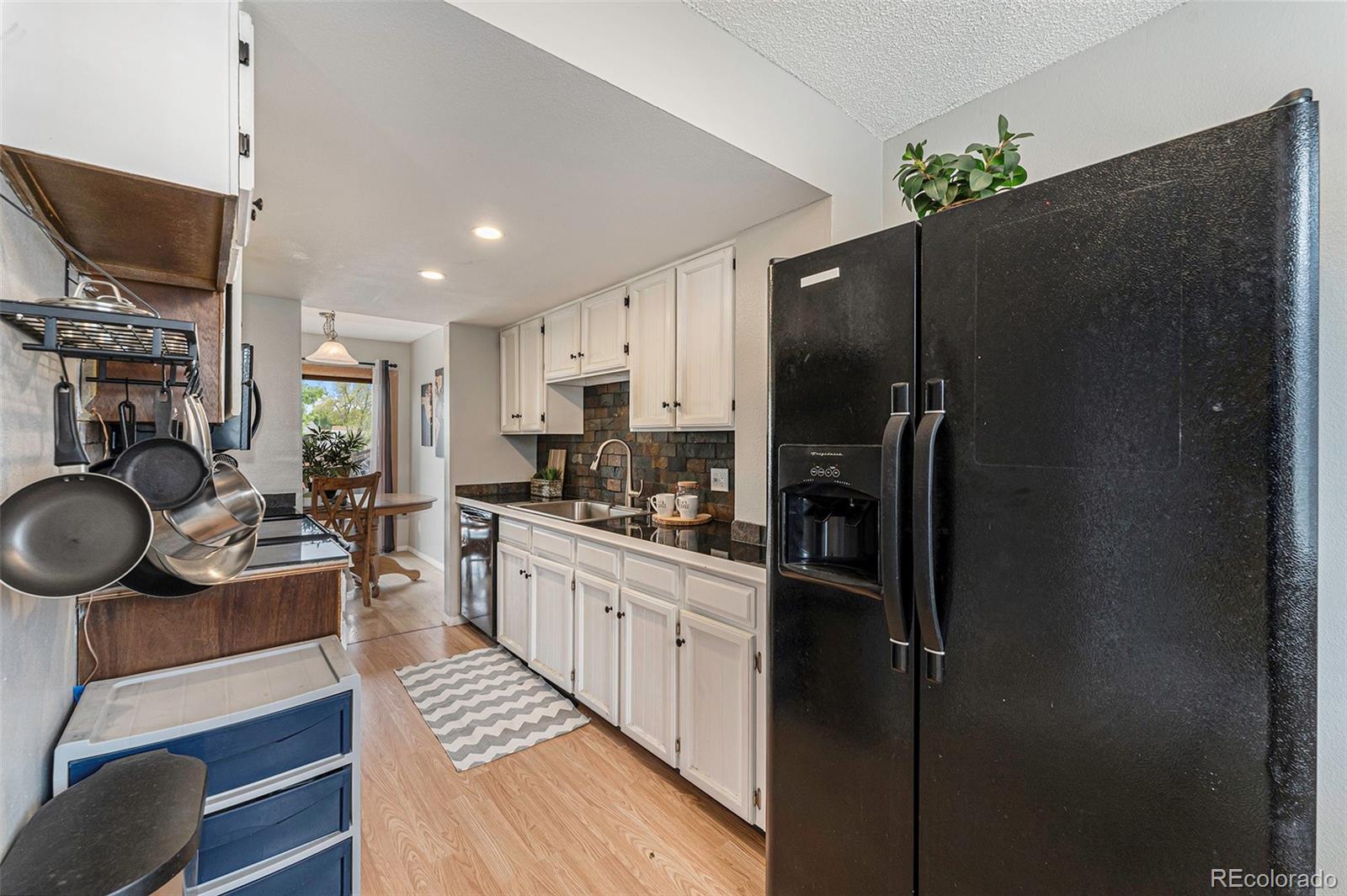 8642 Carr Loop Arvada, CO 80005 - Photo 11 of 22 a kitchen with stainless steel appliances granite countertop a refrigerator stove and sink