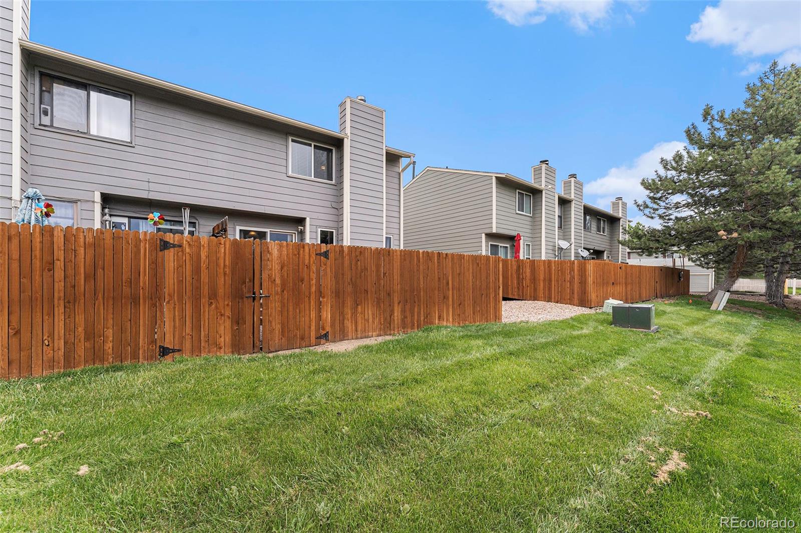8642 Carr Loop Arvada, CO 80005 - Photo 20 of 22 a view of backyard with potted plants and wooden fence