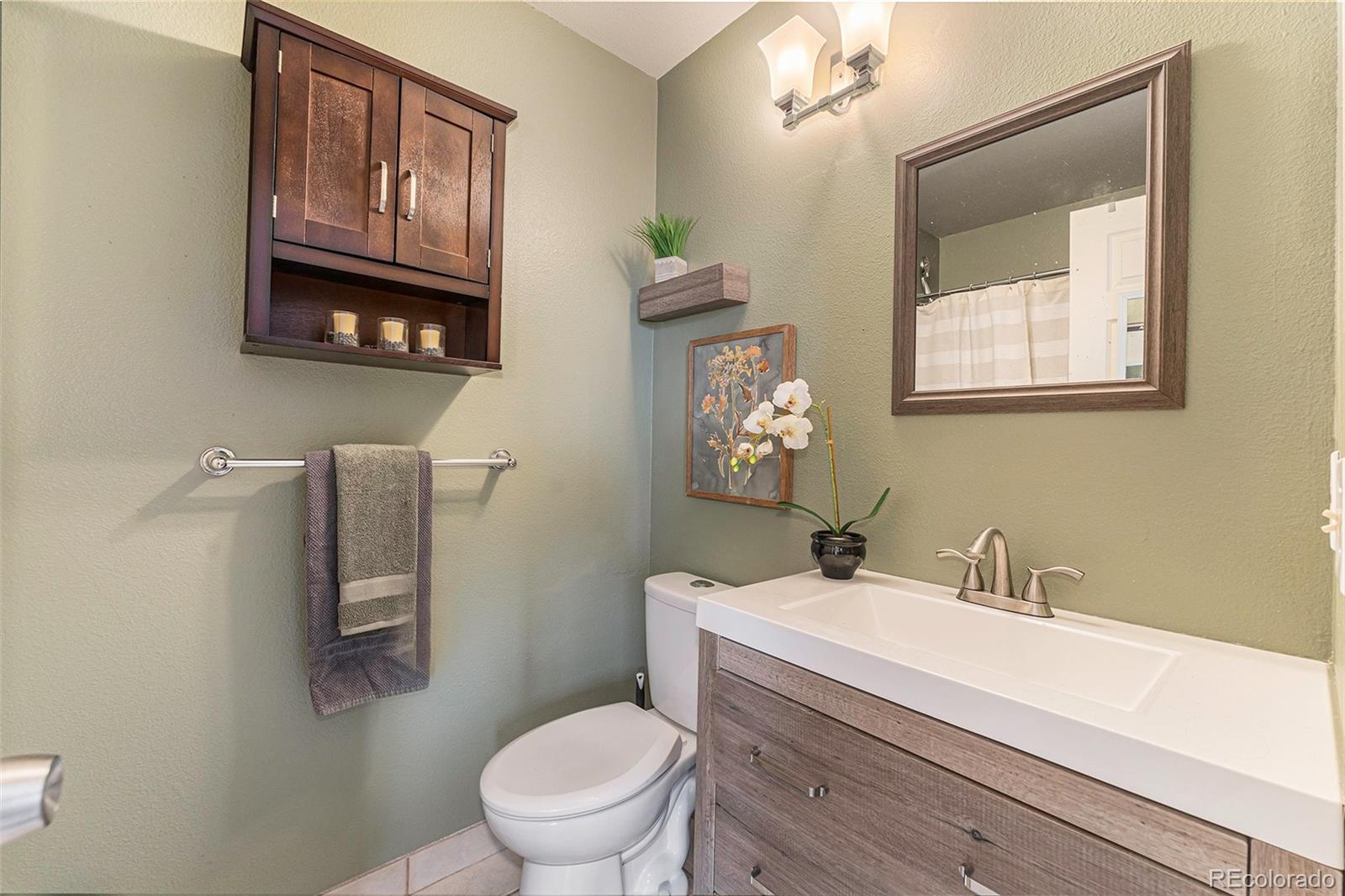 8642 Carr Loop Arvada, CO 80005 - Photo 5 of 22 a bathroom with a toilet a sink and mirror