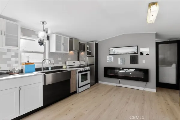 a kitchen with granite countertop white cabinets and stainless steel appliances
