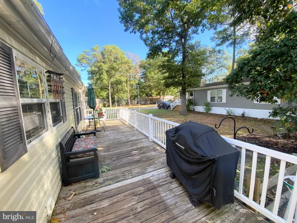 a view of a patio with table and chairs with wooden floor and fence