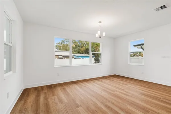 a view of a room with wooden floor and white walls