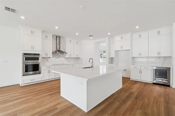 a kitchen with stainless steel appliances white cabinets and a refrigerator