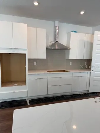 a kitchen with stainless steel appliances a sink dishwasher a stove and white cabinets