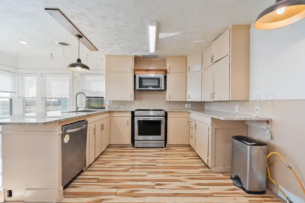 a kitchen with granite countertop a stove top oven sink and cabinets