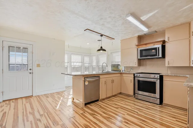 a kitchen with stainless steel appliances granite countertop a stove and a sink