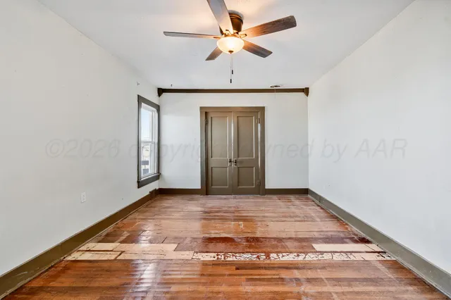 a view of a livingroom with a chandelier fan and wooden floor